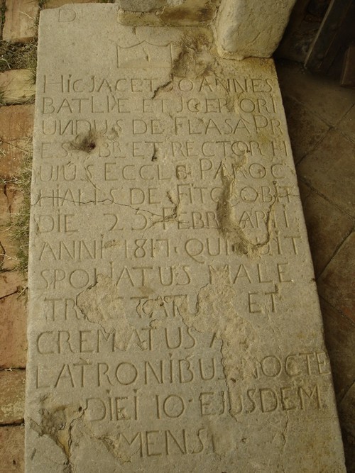 Bajo el zaguán de la puerta de la ermita de Santa Coloma de Fitor encontramos la lápida de la tumba del Rector asesinado en 1817