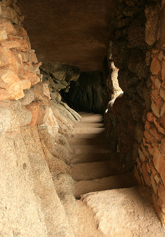Junto a Cala Sa Cova, en dirección al norte, hacia la Cala del Pi, el camino de ronda transita bajo unos preciosos túneles bajo la roca